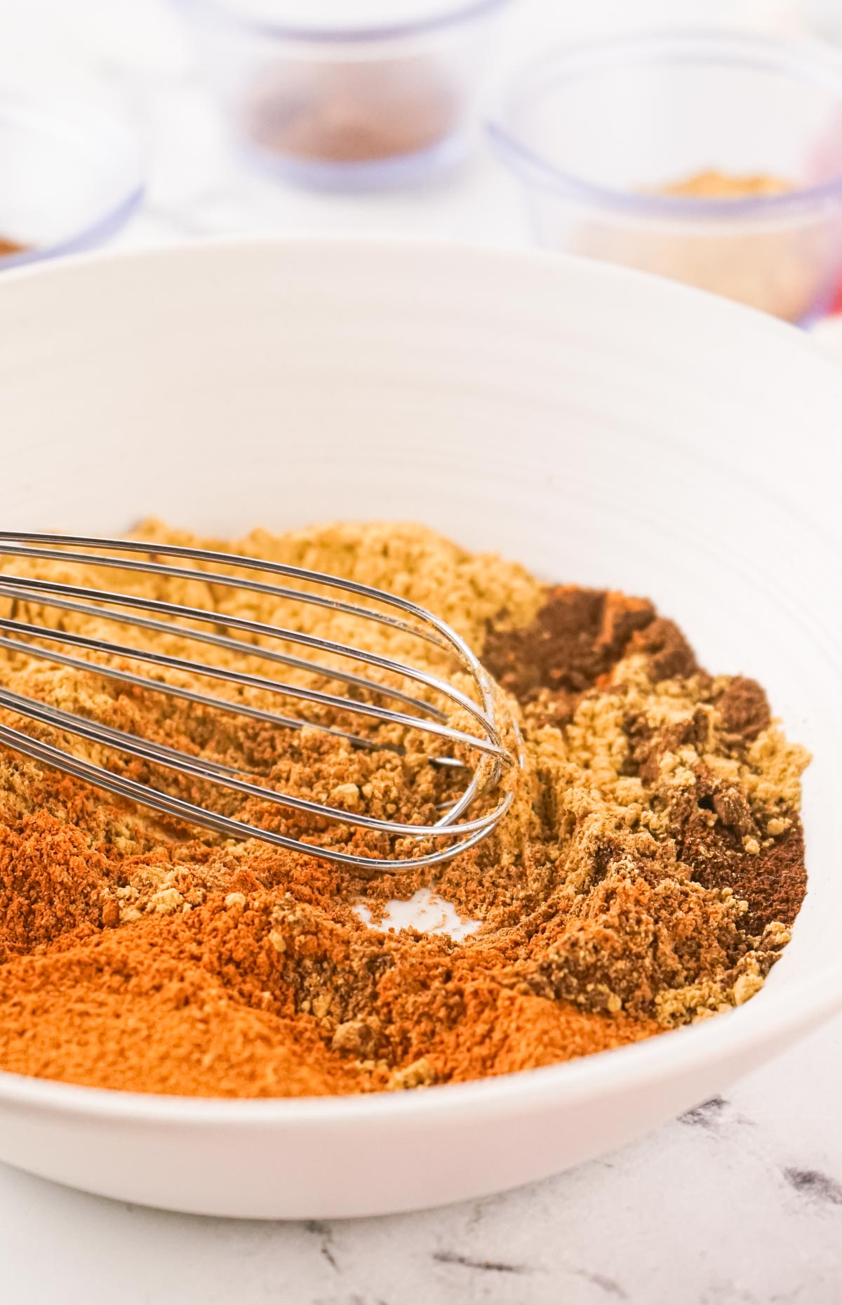 A whisk combing the spices into a mix.