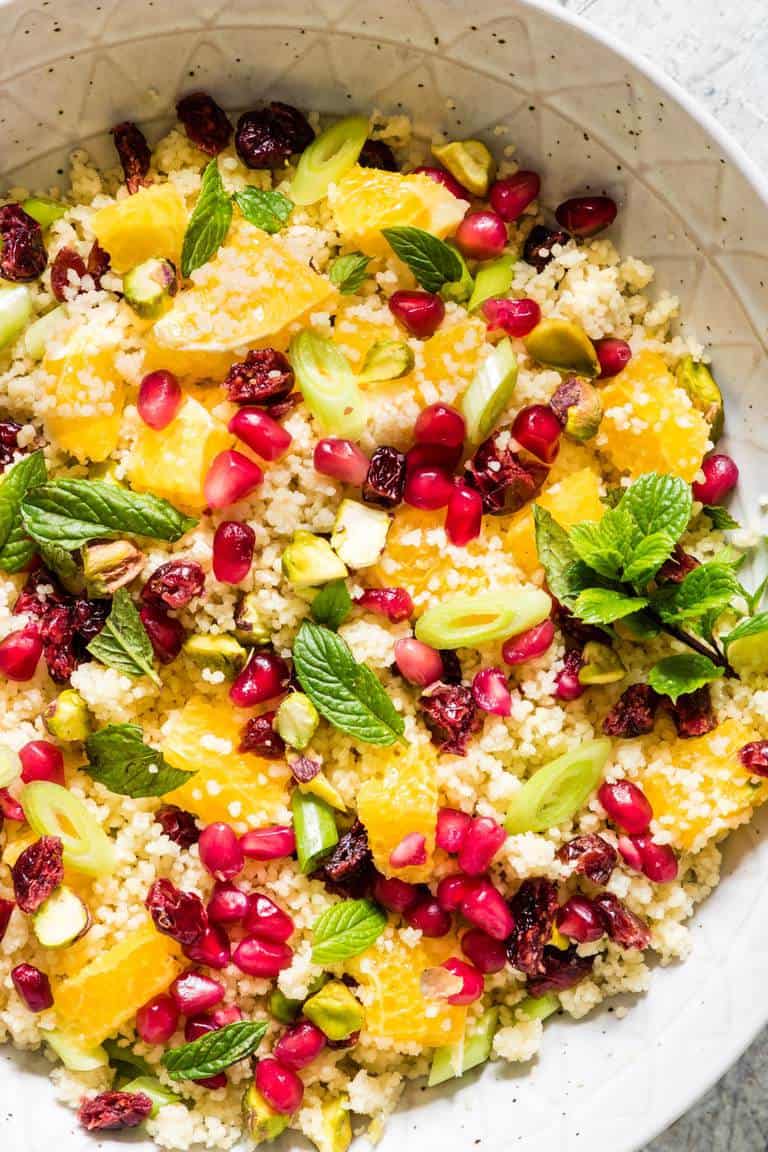 closeup of how to cook couscous with pomegranate seeds in a bowl
