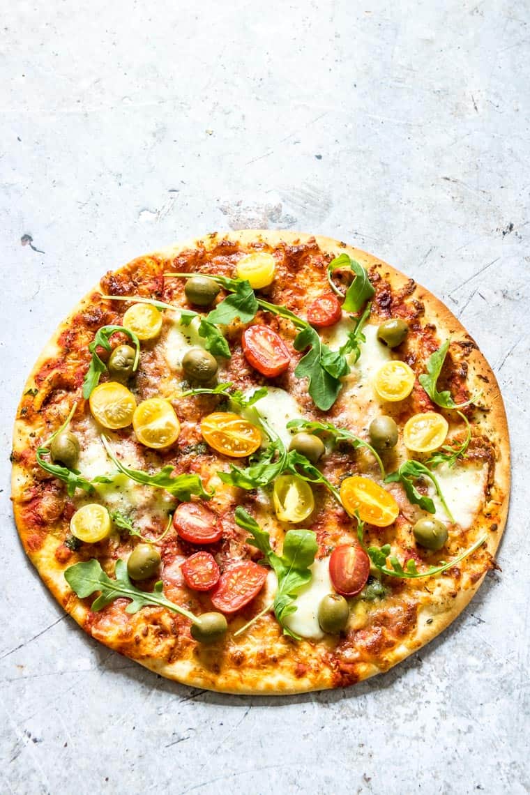 instant pot pizza topped with cherry tomatoes and fresh basil