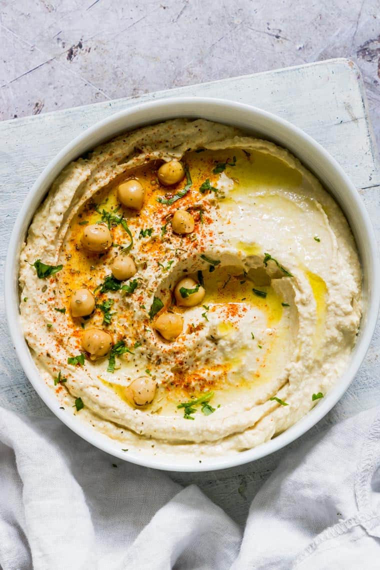 creamy instant pot hummus in a bowl with chickpeas and spices on top