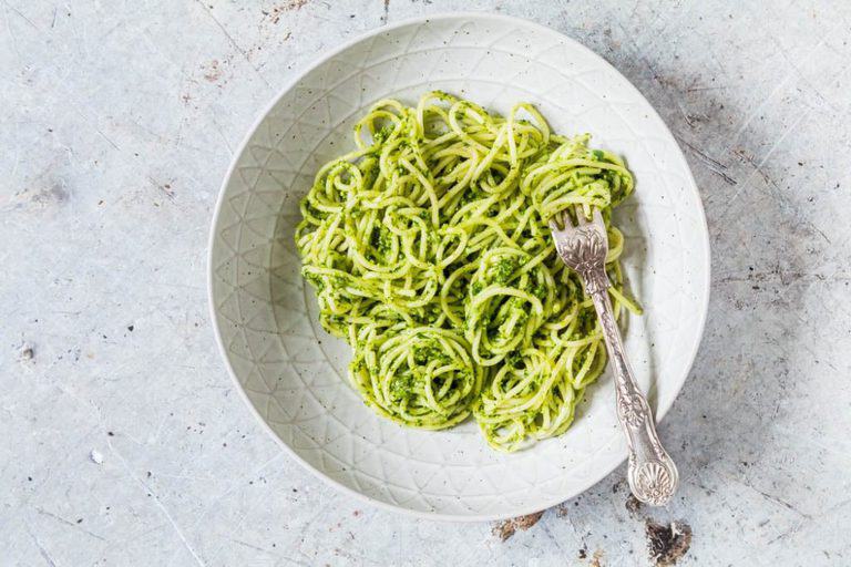 pasta topped with basil pesto sauce and served in a white dish