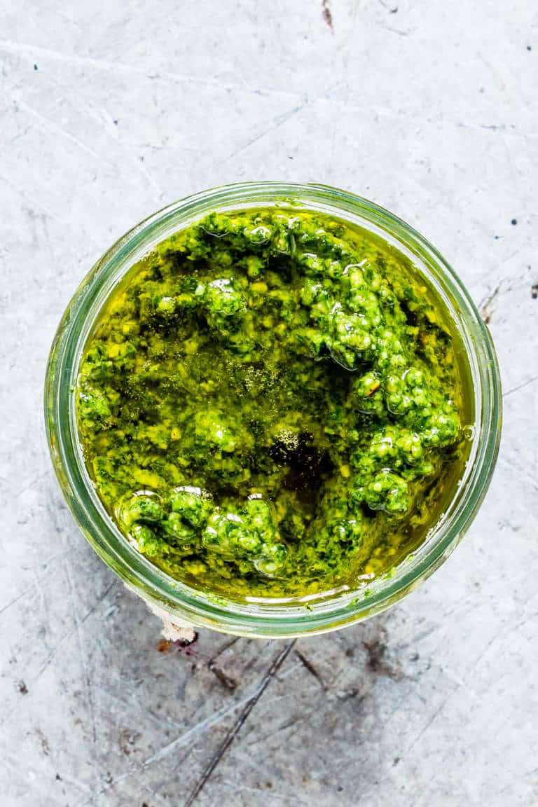 top down view of basil pesto in a glass jar