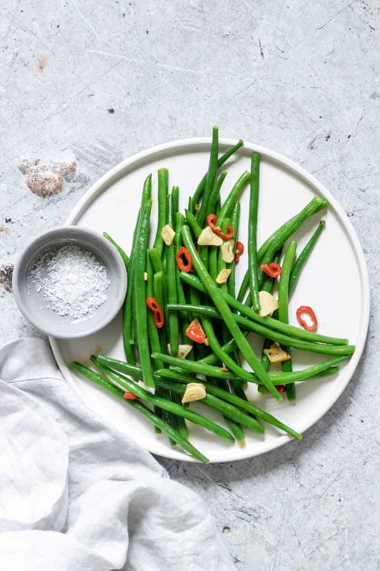 Chilli Garlic Green bean recipe on plate with some salt and napkin