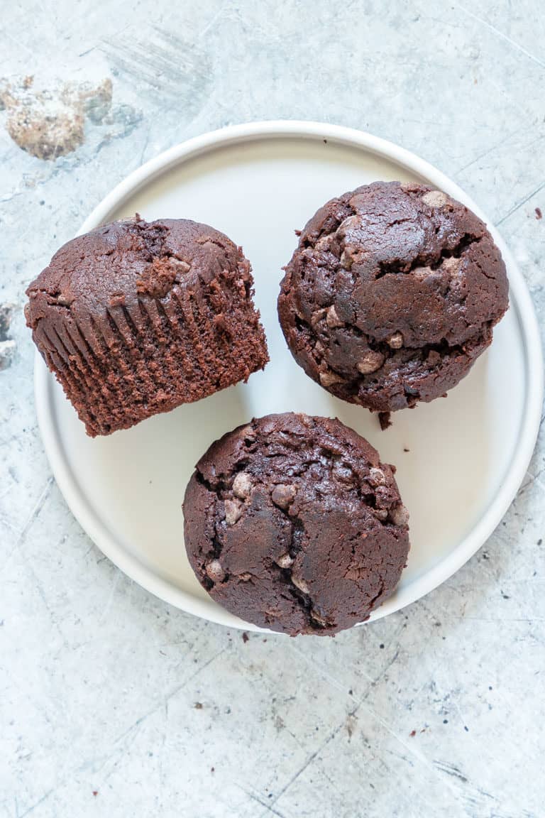 3 chocolate banana muffins on a white plate