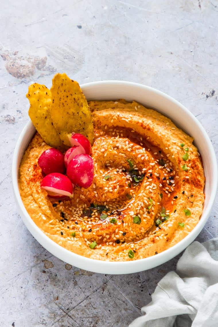 Close up of instant pot pumpkin hummus with radishes and tortilla chips