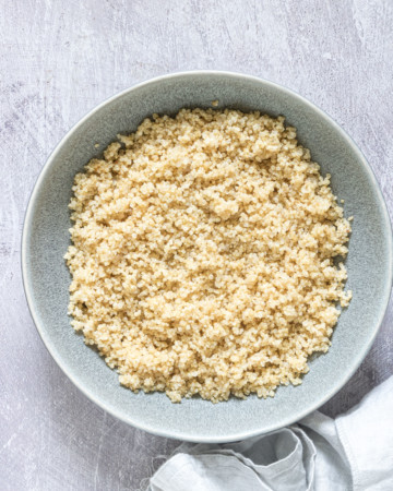 A bowl of cooked quinoa on a table