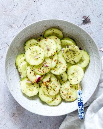 cucumber salad recipe in a bowl with a spoon