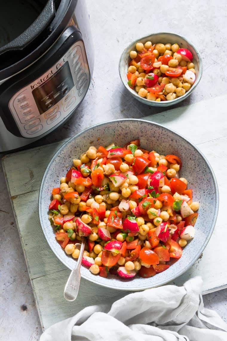 two bowls filled with instant pot chickpeas salad set next to an instant pot