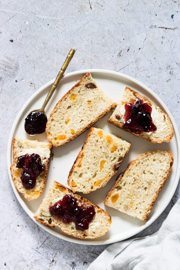 slices of muesli bread with butter and jam on a plate