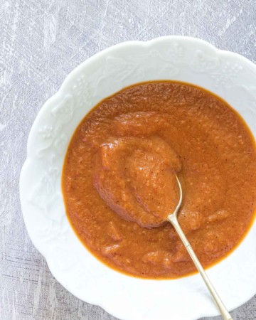 A bowl full of homemade tomato ketchup with a spoon
