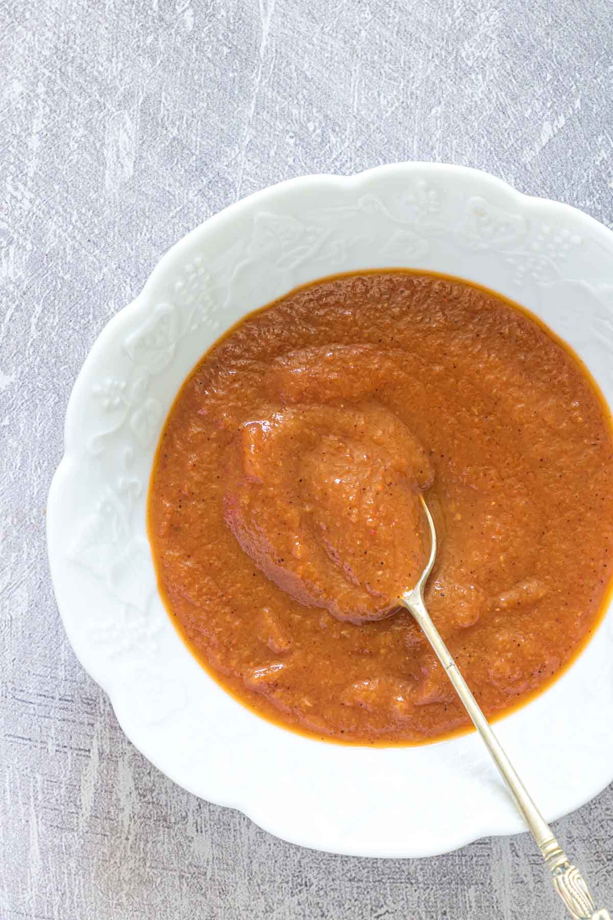 A bowl full of homemade tomato ketchup with a spoon