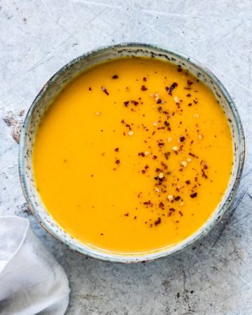a bowl of vegan easy squash soup garnished with chili