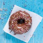 overhead view of nutella donut on a white napkin on a blue background