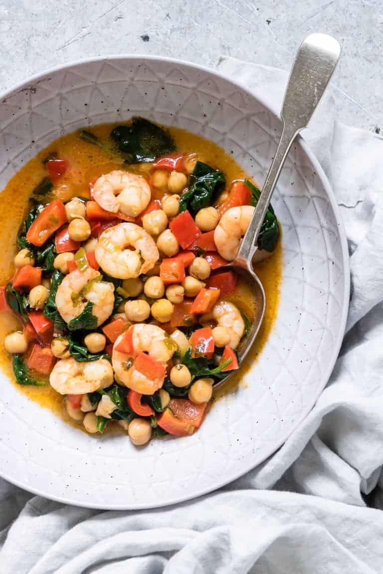 close up of King Prawn Curry and spinach in a bowl
