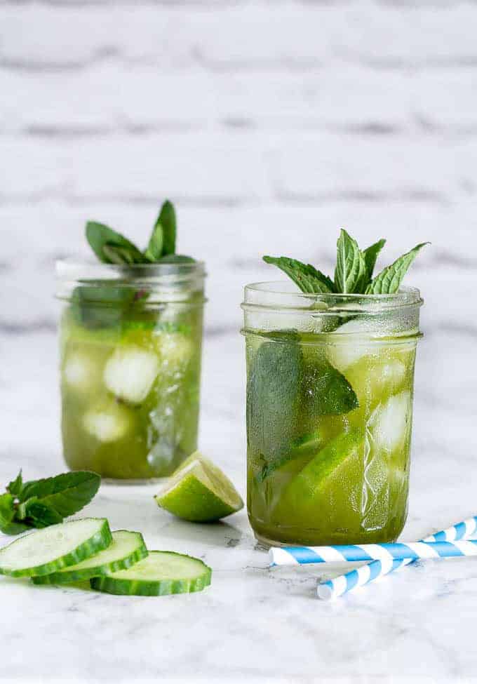 Cucumber Matcha Cocktail in 2 glasses garnished with mint and cucumber