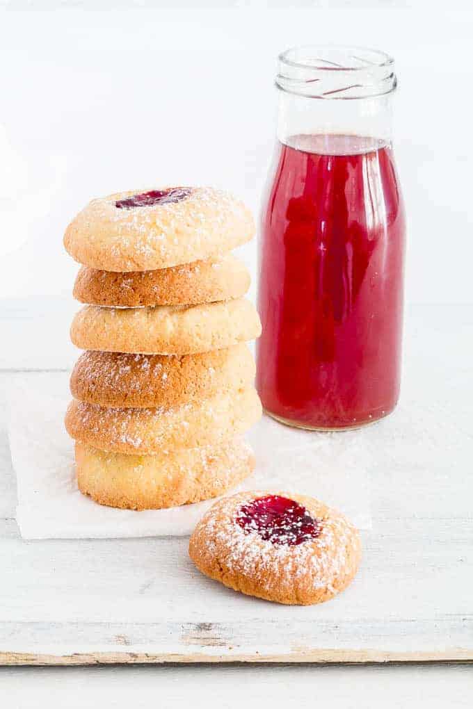 Orange-Cranberry Shortbread Cookies with Jam are easy thumbprint cookies perfect for Christmas. They’re addictive, festive, and fun for kiddoes to make. A perfect Christmas cookie recipe, holiday cookie recipe, or any time of the year cookie recipe. #thumbprintcookies #thumbprintcookierecipe #cookierecipes #jamfilledcookie #christmascookies #holidaycookies