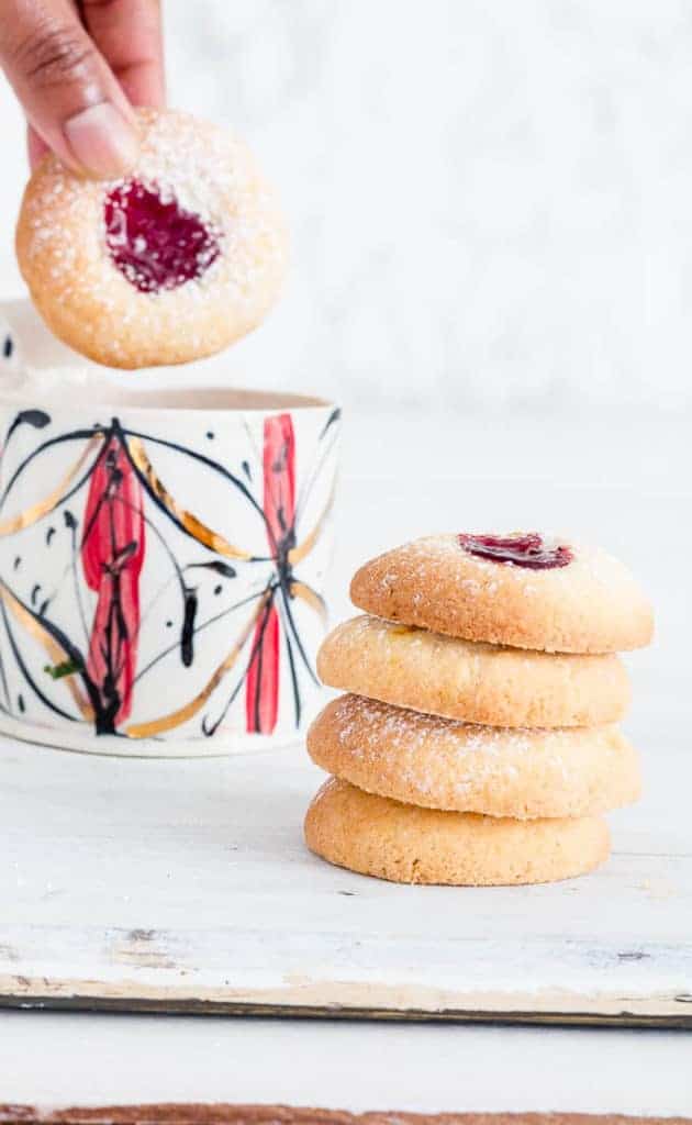 Orange-Cranberry Shortbread Cookies with Jam are easy thumbprint cookies perfect for Christmas. They’re addictive, festive, and fun for kiddoes to make. A perfect Christmas cookie recipe, holiday cookie recipe, or any time of the year cookie recipe. #thumbprintcookies #thumbprintcookierecipe #cookierecipes #jamfilledcookie #christmascookies #holidaycookies