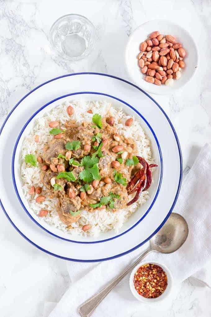 pork satay recipe with peanut sauce inside a white bowl on a white towel