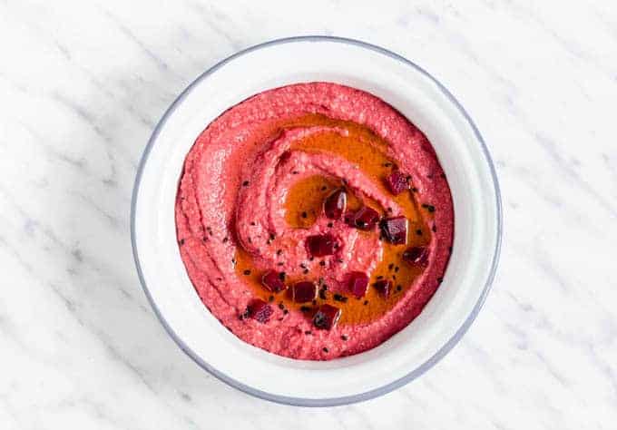 Olive Oil and Beetroot Hummus In A bowl topped with beetroot pieces