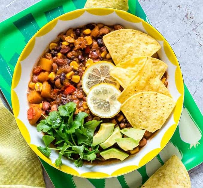 Slow cooker three bean chili in a bowl with toppings