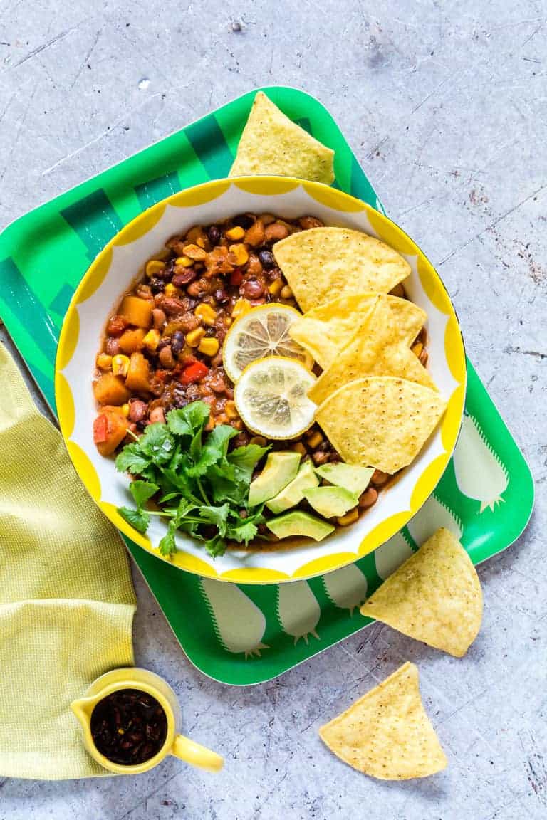 Slow cooker three bean chili in a bowl with toppings