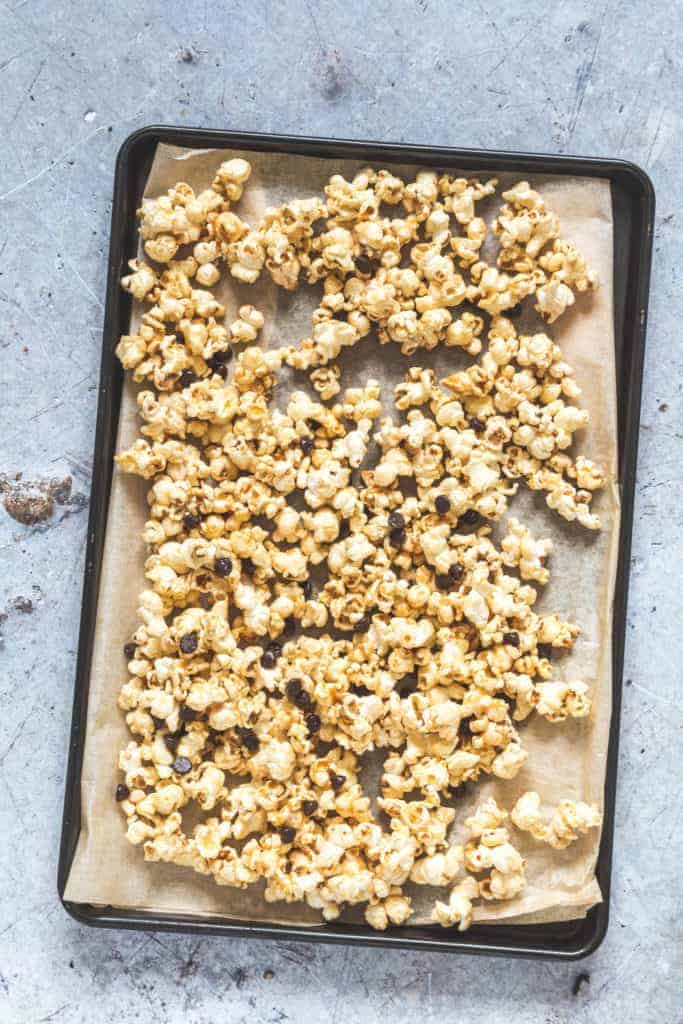 Easy and delicious Caramel Popcorn on a baking tray with chocolate chips