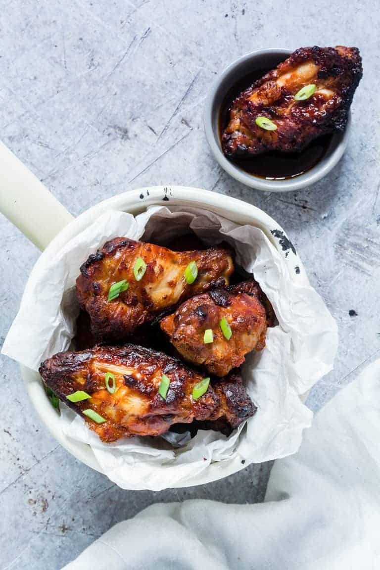 iceland hot chicken wings in two containers with spring onions on top