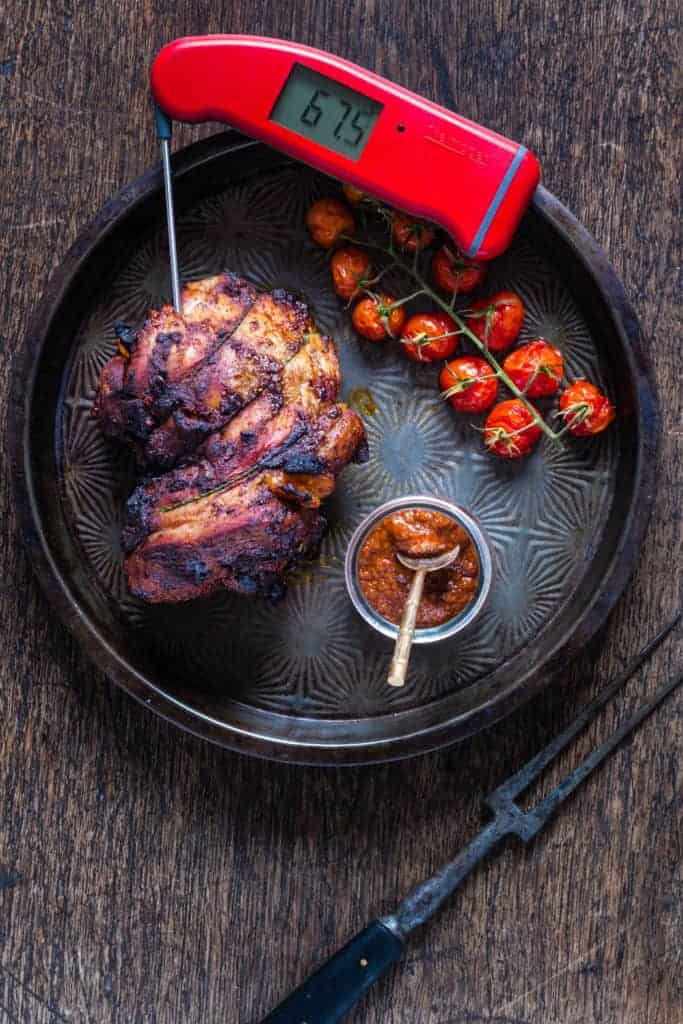 This roast lamb stuffed with harissa apricots with a thermometer reading the temperature