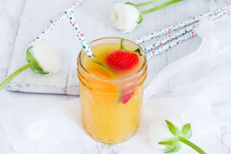 Pineapple daiquiri cocktail on a table with straws and flowers. recipesfromapantry.com