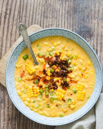 a bowl of instant pot corn chowder on a table with a spoon in it