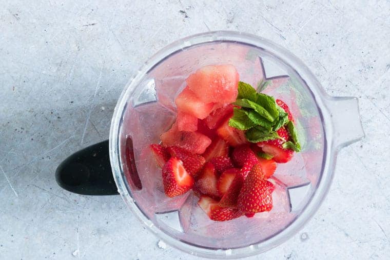 watermelon and strawberry and herbs in a blender to make watermelon popsicles