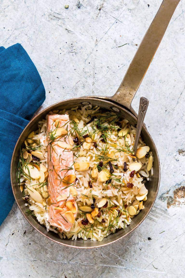 one pan salmon and rice with dill and almonds on a table