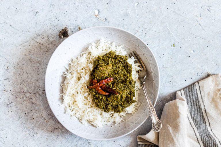  cassava leaf stew palava sauce served with some steaming white rice. 