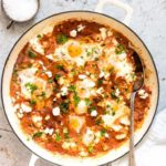 overhead view of Shakshuka With Feta in a cast iron pot with a spoon sticking out