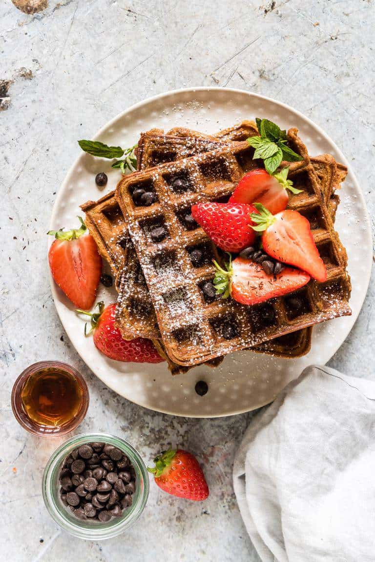 Delightfully fluffy & easy chocolate chip sweet potato waffles recipe with berries with a Halloween twist your guests will love. See more at recipesfromapantry.com #sweetpotatowaffles #easysweetpotatowaffles #chocolatechipwaffles #sweetpotatochocolatechipwaffles #wafflerecipes #halloweenrecipes