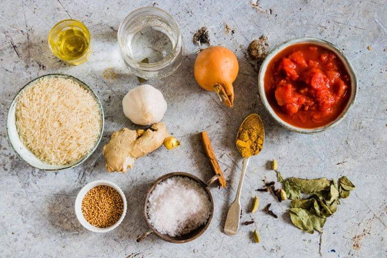 south Indian tomato rice ingredients - rice, chopped tomatoes, oil, onion, garlic, ginger, water, mustard seeds, cinnamon, curry leaves, spices