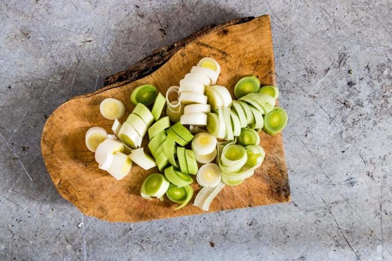 Sliced leeks on a wooden chopping board