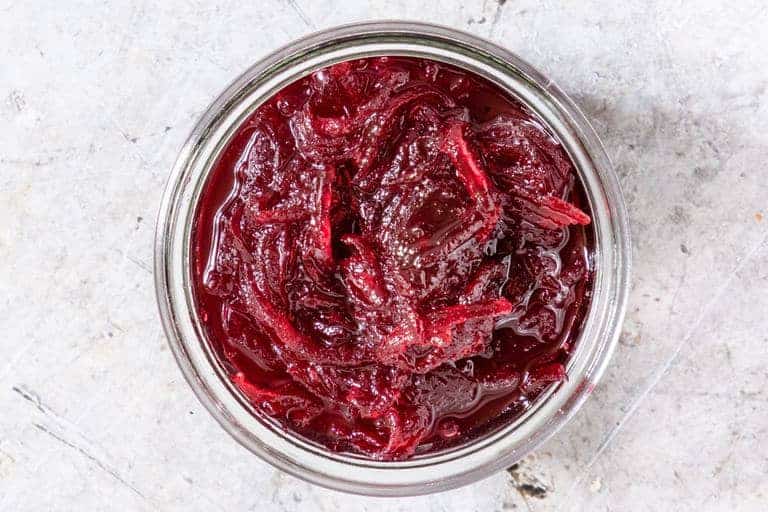 closeup of beetroot relish on table in clear glass jar