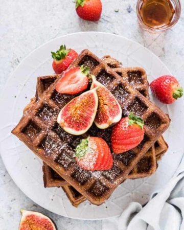 overhead view of gingerbread buckwheat waffles covered in figs and strawberries