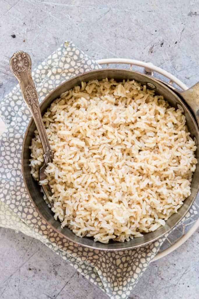  Instant Pot Brown Rice in a pot with a fork and a spotty cloth