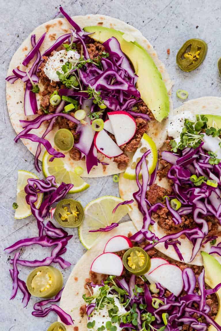 open face corned beef tacos with shredded cabbage, avocado, and other vegetables