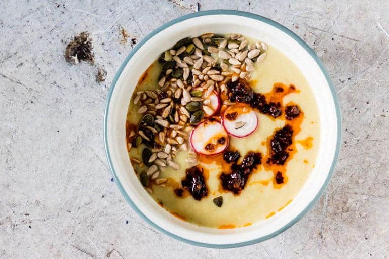 Instant Pot Potato Soup in a bowl, with pumpkin seeds , chilli and radishes shot from overhead