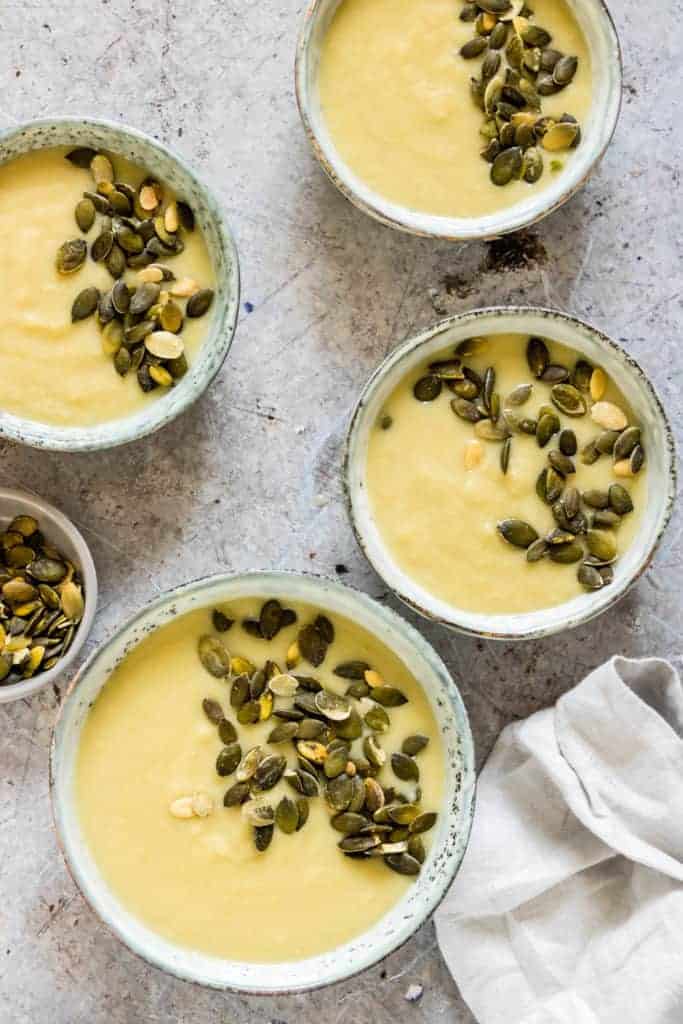 Instant Pot Potato Soup in four bowls, with pumpkin seeds and a grey cloth