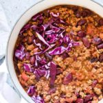 Instant Pot Chilli in a white pot with red cabbage shredded on top