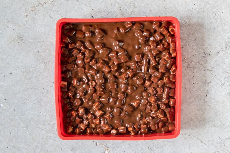 overhead view of rocky road cake in a red square pan