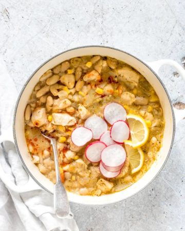 pot of white chicken chili recipe garnished with radishes next to a white towel