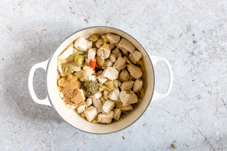 overhead view of pot containing white chicken chili ingredients including spices