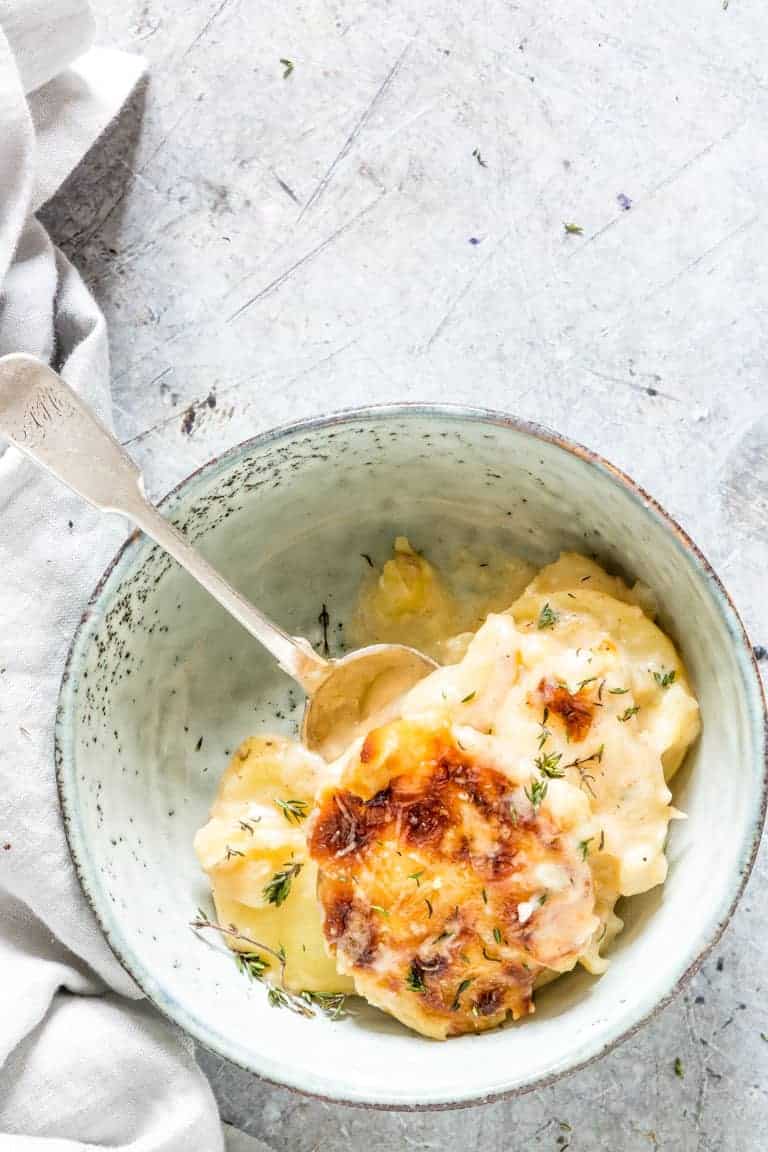 one serving of instant pot scalloped potatoes in a blue dish