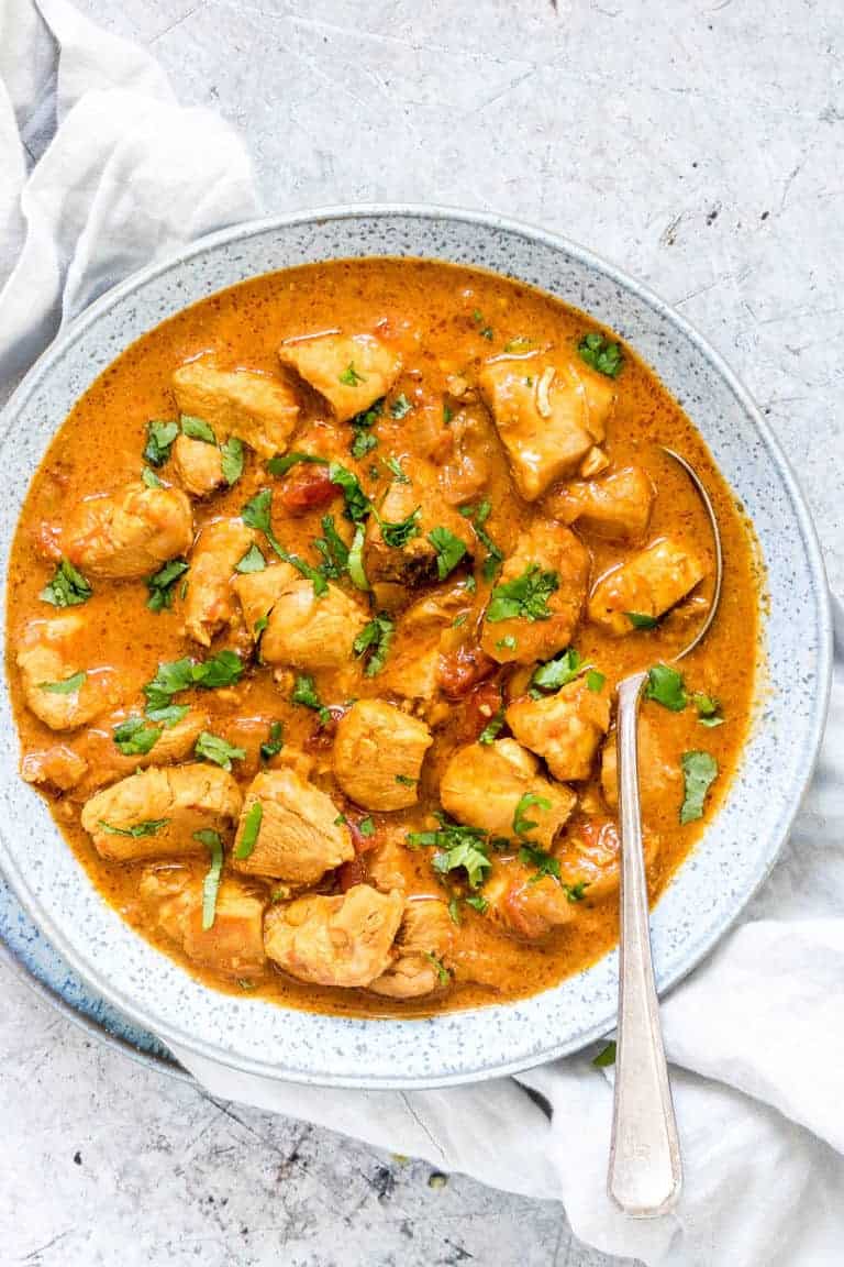 spoon inside large bowl of instant pot chicken curry on top of countertop