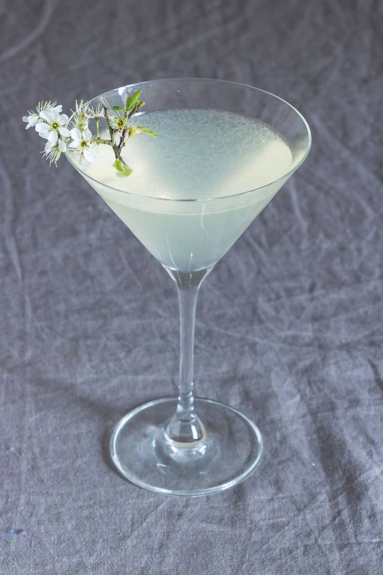 overhead view of lemon drop martini with white flowers on one side